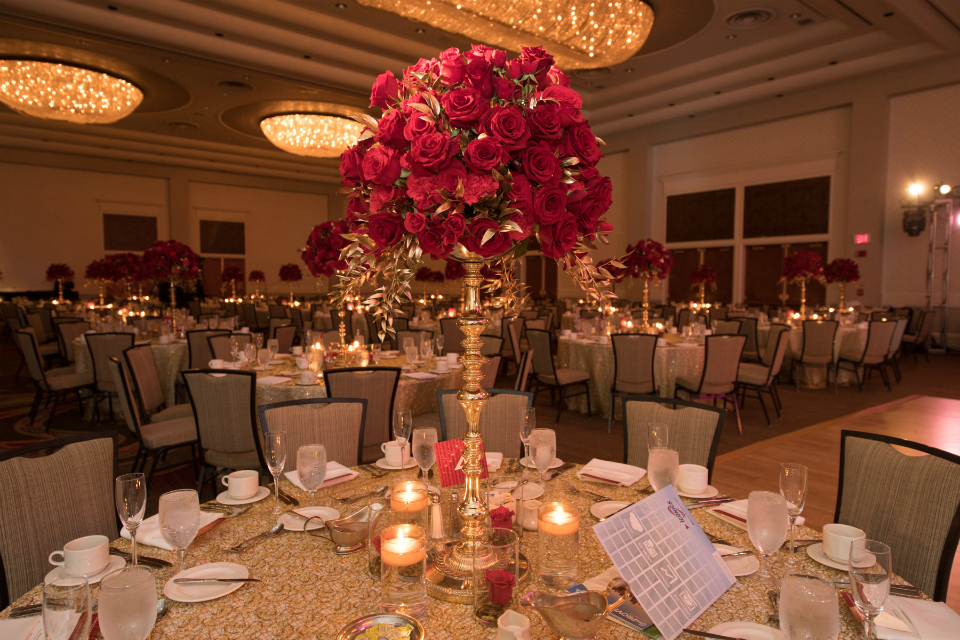 Red roses in tall gold vases by Stapleton Floral Design