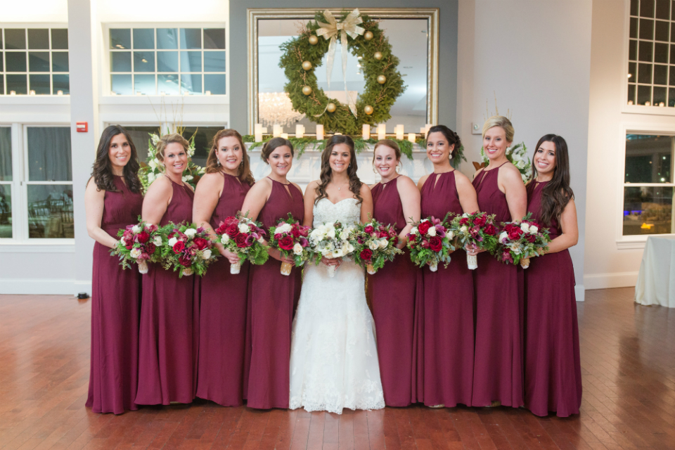 Maroon bridesmaids dresses with cream and red roses bouquet