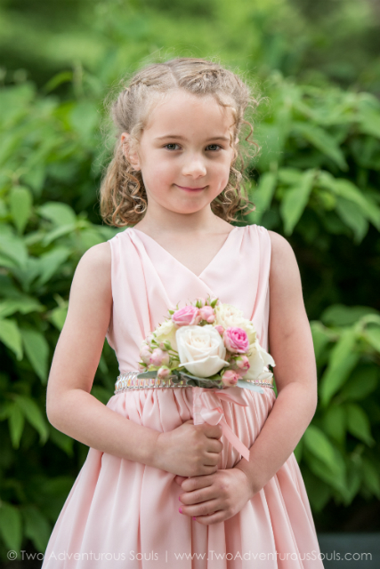 Flower girl wearing a pink dress and holding a floral wand