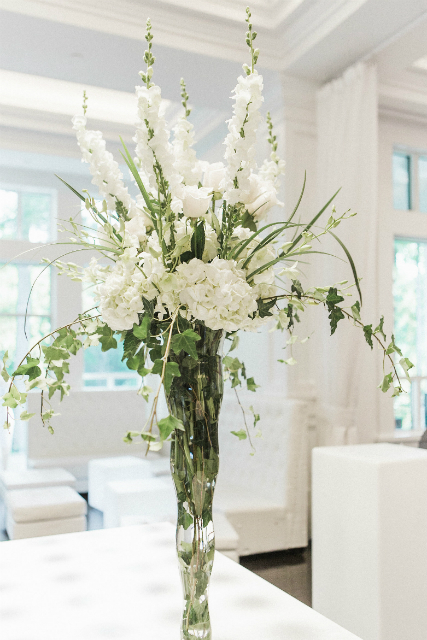 tall centerpiece with white flowers and greenery