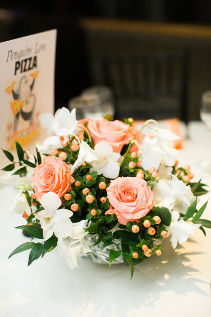 Low centerpiece with pink roses, white blossoms, and berries by Stapleton Floral Design