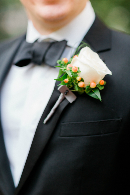 Simple white rose boutonniere with berries