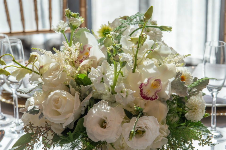 Floral arrangement with white flowers and accents of greenery