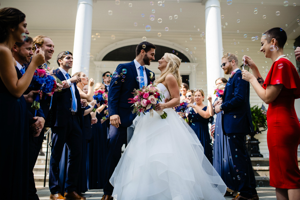 Bride and groom walking out the church with bubbles