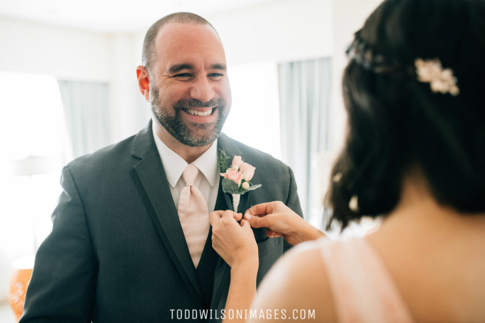 Bride putting on boutonniere on groom