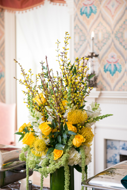 Tall centerpieces spring theme with yellow roses and accents of greenery