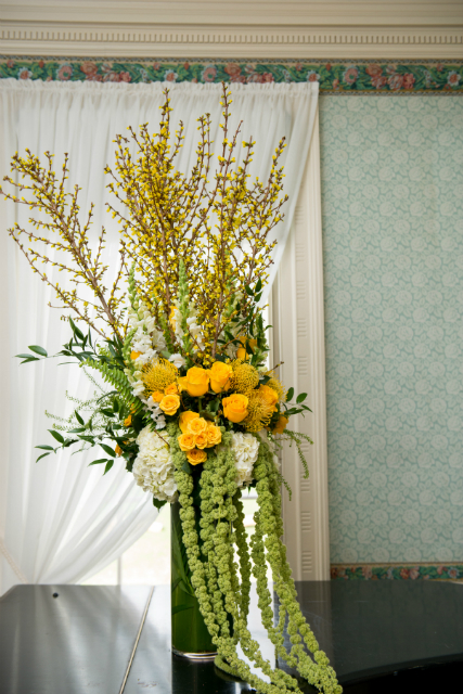Tall centerpieces spring theme with yellow roses and accents of greenery