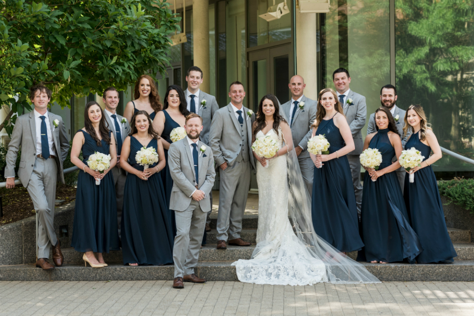 Bridal party in navy dresses and groomsmen in gray suits