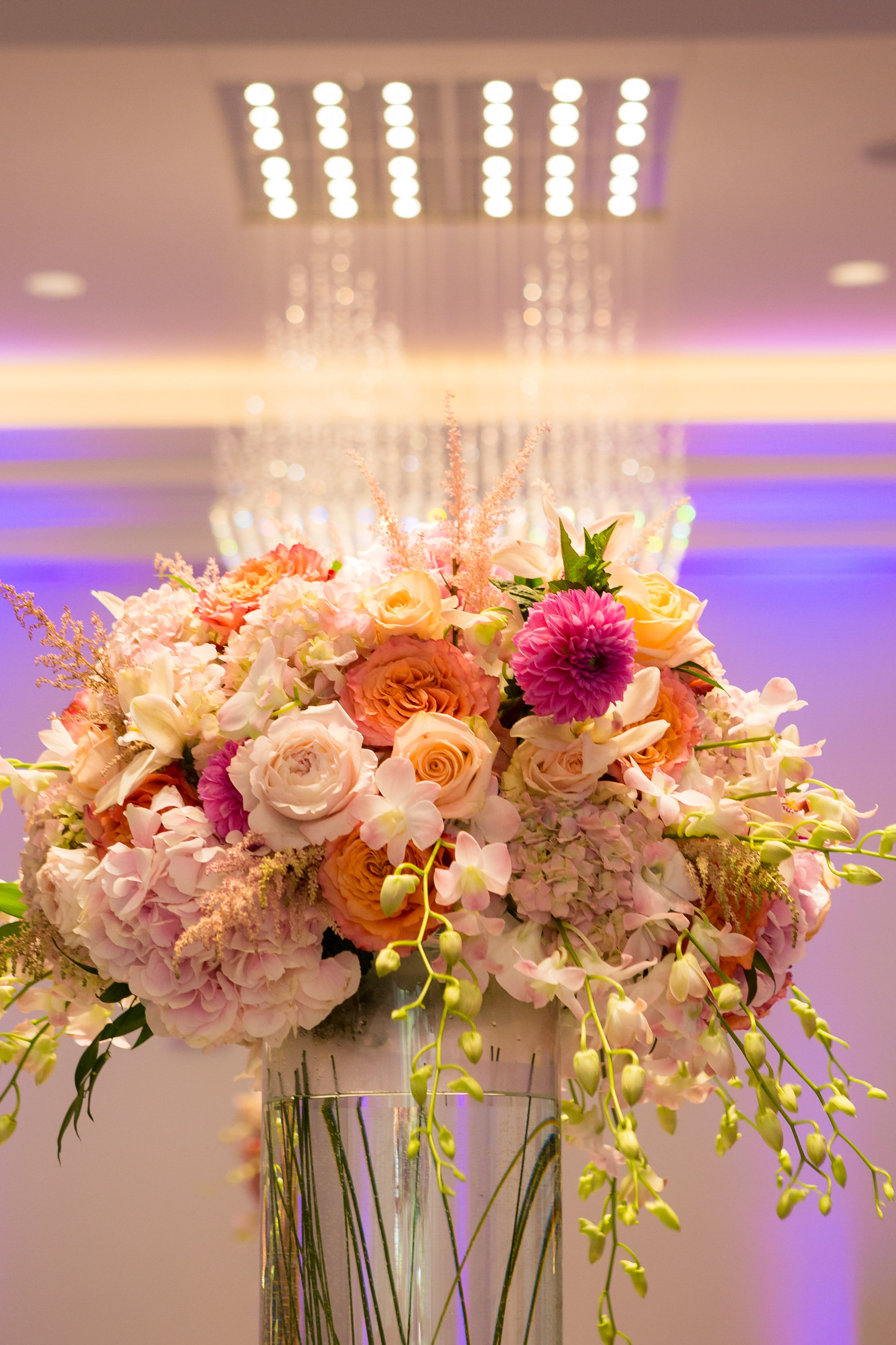 Pink, orange, and yellow roses for tall wedding centerpieces