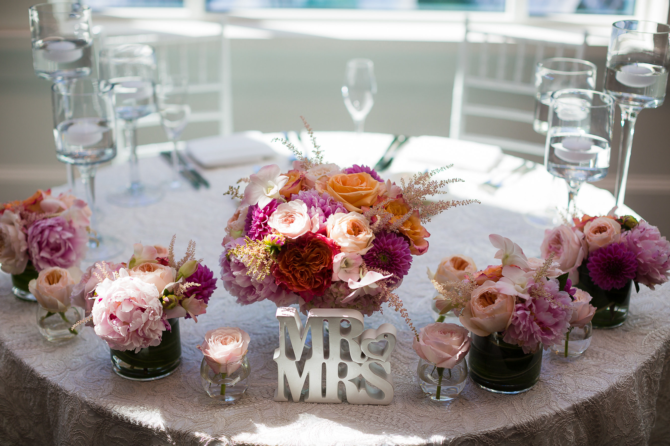 Mr. & Mrs. sweetheart table with summer color palette flowers