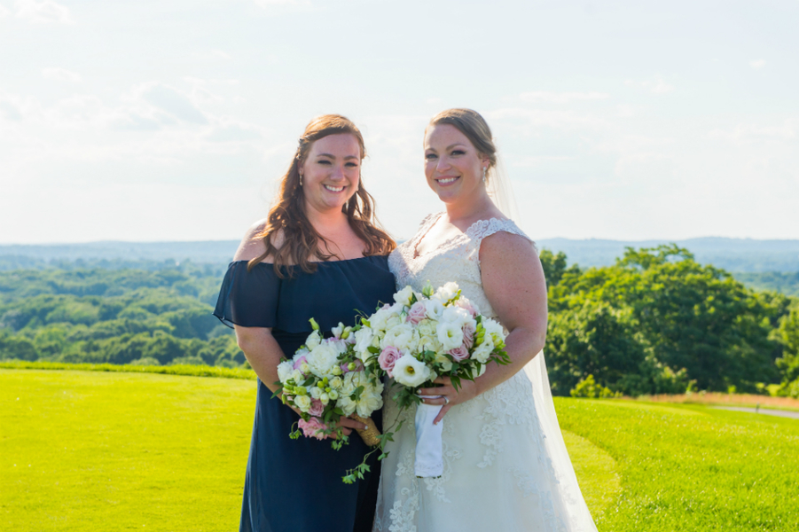 Bride and her bridesmaid weaing a navy dress