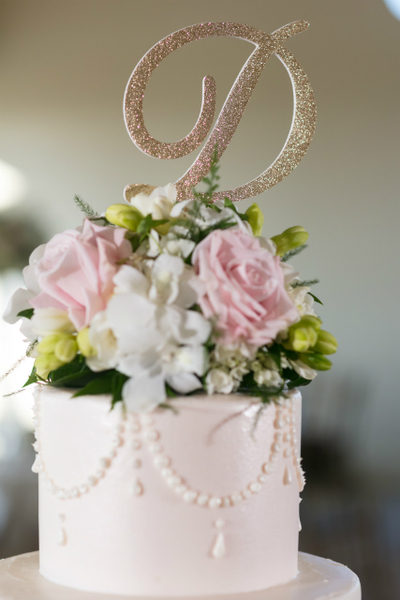 Wedding cake with white and light pink roses on top