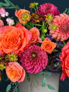 Close-up of the Harborside Harvest floral arrangement with sunset toned dahlias and Free Spirit roses