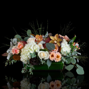 Elegant Thanksgiving floral centerpiece with orchids, roses, hydrangea, and fall textures from Stapleton Floral.